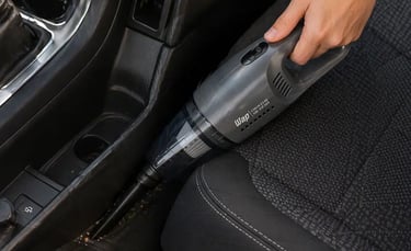 Aspirador automotivo WAP 180W sendo usado para limpar cantos difíceis entre banco e console do carro