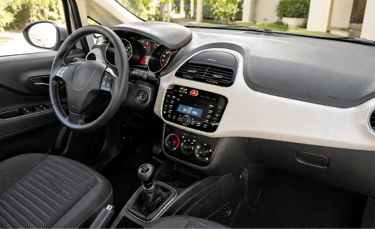 Interior do Fiat Punto 2015 durante o dia mostrando acabamento e câmbio manual