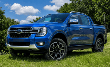 Ford Ranger V6 azul em área rural, vista frontal 3/4, sem placa dianteira.