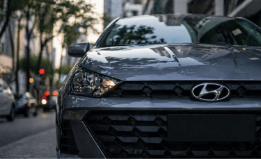 Hyundai HB20 em close na grade frontal estacionado em rua urbana no Brasil