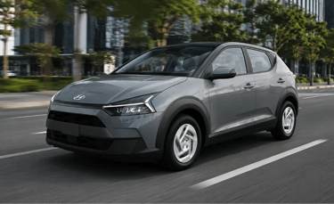 Hyundai i20 Comfort 2026 cinza em movimento em avenida urbana