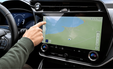Motorista usando tela digital no painel de um carro moderno durante a condução