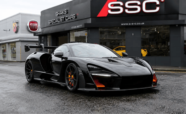 McLaren Senna preto estacionado em frente a concessionária de supercarros