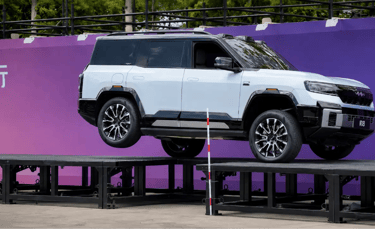 SUV chinês da BYD levantando uma roda durante demonstração de suspensão inteligente