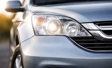 Detalhe frontal de SUV com farol aceso e design moderno em close, imagem parcial