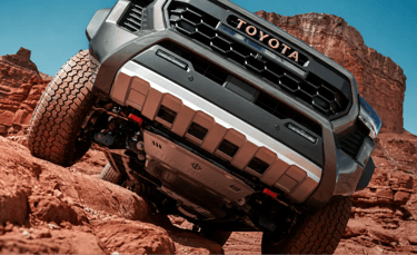 Picape Toyota enfrentando trilha rochosa em terreno off-road