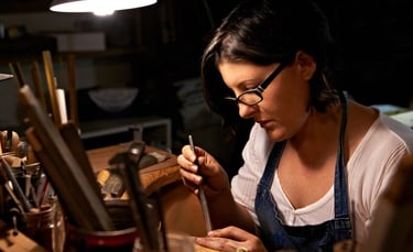 Artesana joyera elaborando joyería hecha a mano con herramientas de precisión en un taller