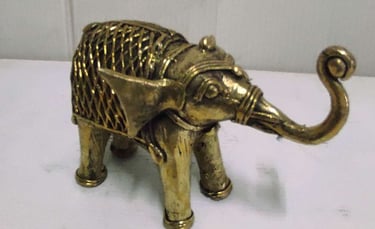 "Finely crafted brass baby elephant with raised trunk and ornate tribal motifs-For global distribution"