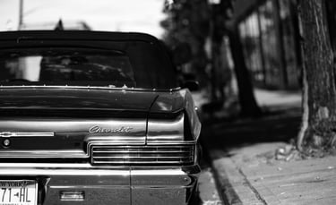 a classic chevrolet car with a soft top and ny license plates parked on a brooklyn street
