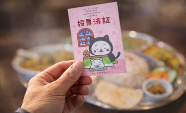 投票済証を手に持ち、飲食店の料理を背景にした選挙割のイメージ画像｜堺市のニュースならサカイタイムズ