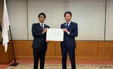 サカイタイムズ編集部アシスタント の発言：  堺市役所で行われた感謝状贈呈式で、株式会社米田商店の米田幸樹代表取締役と永藤英機市長が感謝状を持って撮影に臨むようすを写した写真｜堺市のニュースならサカイタイムズ