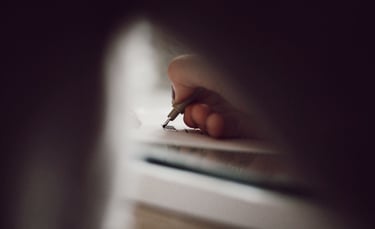 a person writing on a piece of paper