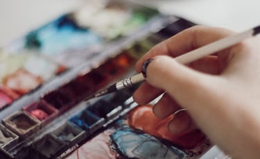 a person holding a paintbrush and a paintbrush in their hand