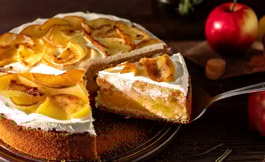 apfelweintorte, anschnitt, man sieht den boden, die füllung und die sahnedecke + deko mit zimt