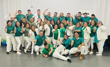 A cheerful group of people in matching teal and white attire posing for a team photo.