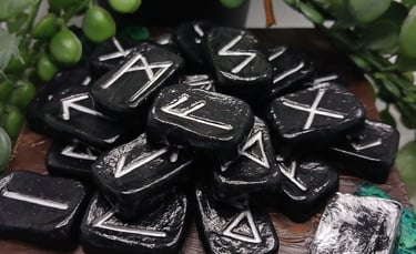 A pile of black Elder Futhark rune stones with silver engravings resting on a wooden altar.