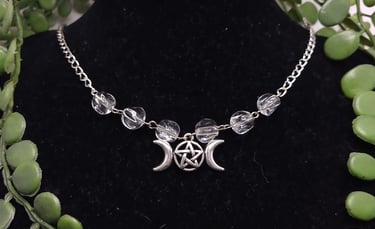 Silver triple moon goddess pentacle necklace with clear crystal beads on a black jewelry display bust.