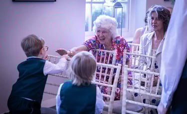 Smiling grandmother high-fiving young page boy at Bury St Edumnds Regsitry Office wedding ceremony.