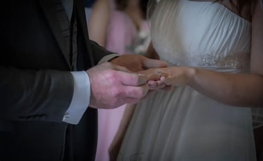 groom placing a wedding ring on his brides finger