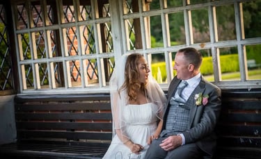 newly-weds sitting chatting on a park bench