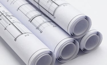 A welcoming office space with blueprints and design sketches spread out on a wooden desk.