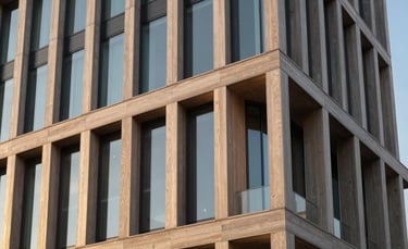 A dignified and artistic photography shot of an architectural detail of a modern foundation building in the US, featuring clean lines, glass, and warm wood textures, bathed in golden hour light.