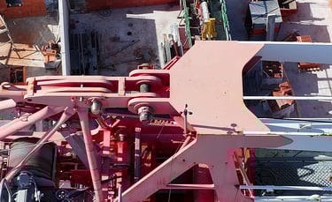 Vue aérienne d'une grue à tour rouge sur un chantier de construction fréquenté avec des matériaux
