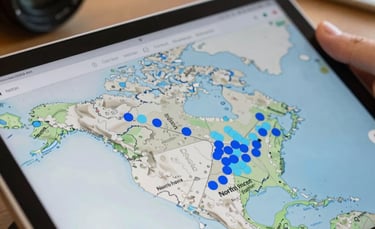 A close-up shot of an interactive digital map on a tablet screen showing North American freight lanes with blue and light blue markers, professional office background.