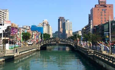 Canal de Keelung com a cidade ao redor, visto do porto, mostrando barcos e áreas urbanas costeiras..