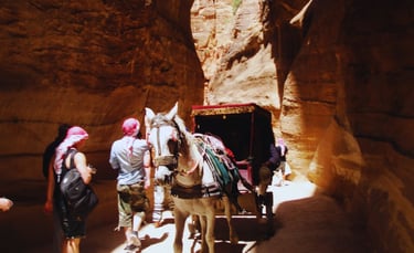 Descida do Siq em Petra com vista de burro e carruagem seguindo pelo caminho estreito.