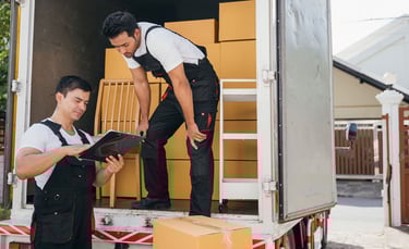 dos trabajadores de mudanza descargando un camión