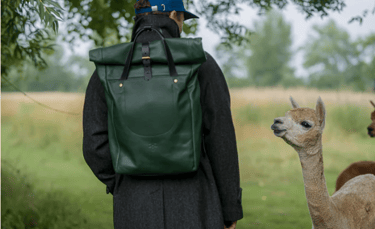 Billy Tannery Rolltop Backpack made from chestnut goat leather displayed on wooden stool