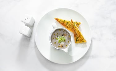 a plate with a bowl of soup and a spoon