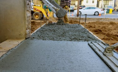 a man is laying concrete on the ground
