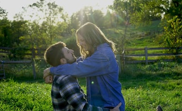 a man and woman sitting on the grass