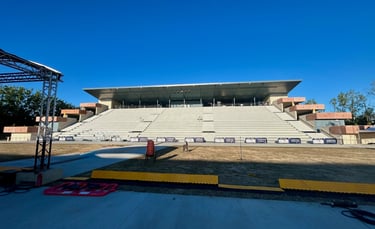 Stade d'amphithéâtre extérieur vide avec des sièges en béton à plusieurs niveaux et un toit en métal