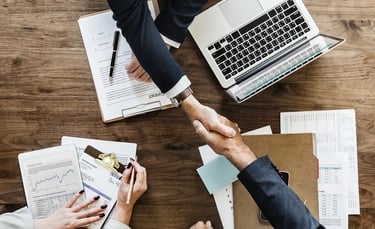 a group of people shaking hands over papers
