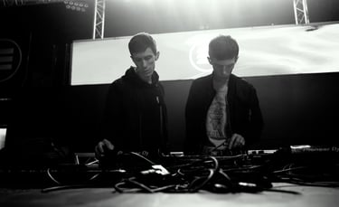 Twins brothers standing in front of a stage with a large screen