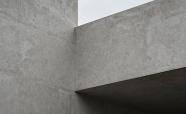 Modern minimalist architecture detail with clean lines and soft grey concrete, a glimpse of the Spanish-speaking sky, quiet and balanced composition.