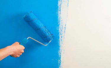 Rolling blue paint on wall