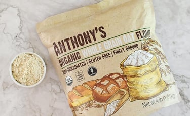 A bag of Anthony's Organic Whole Grain Oat Flour next to a small bowl of finely ground gluten-free flour.