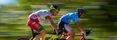 two men riding bikes on a road