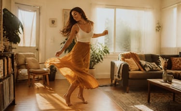 A happy woman dancing in a sunlit living room wearing a white crop top and flowing yellow skirt.