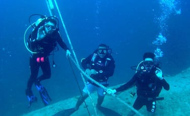 a group of divers in scuba gear on a shipwrwrack