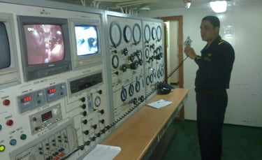 Captain Essam in uniform standing in front of a control panel