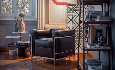 Modern leather armchair beside bookshelves and soft window light, showing a calm and practical livin