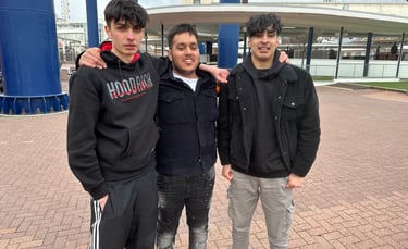 three men standing next to each other in front of a building