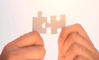 Deux mains s'apprêtent à assembler deux pièces de puzzle, représentant la collaboration et la recherche de solutions.