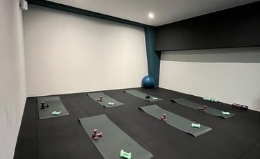 Sala fitness della palestra Move 2 Grow a Milano con tappetini, manubri e attrezzature per allenamenti di gruppo.
