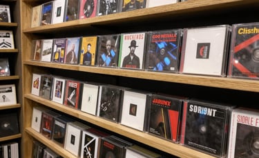 A stack of vinyl records with colorful album covers featuring folk and country themes